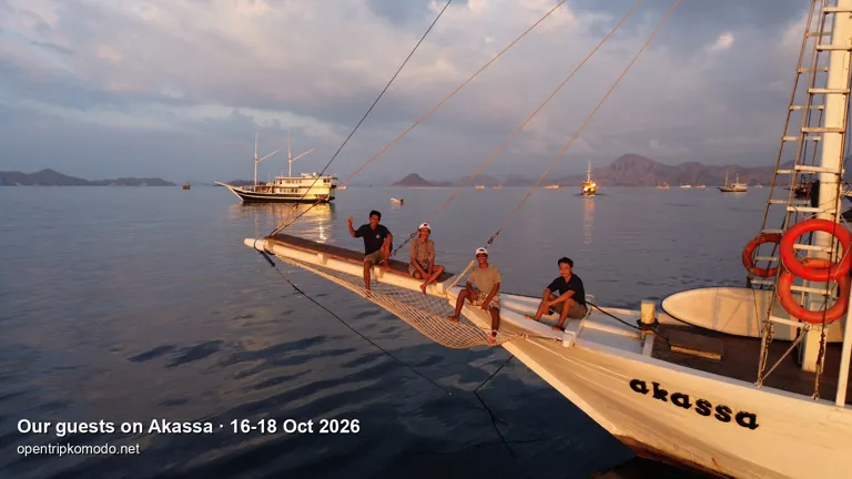Tamu trip Akassa duduk di haluan kapal saat senja, dari udara