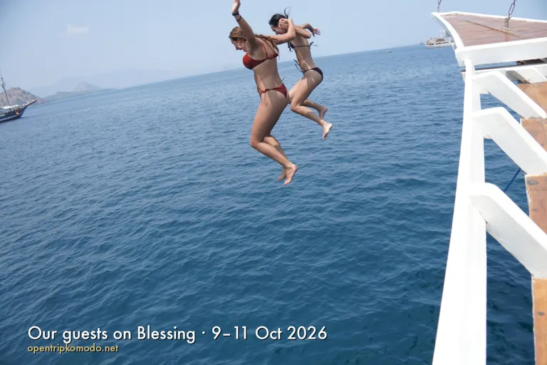Dua tamu trip Blessing melompat dari pinggir kapal ke laut biru