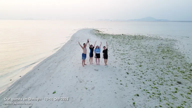Rombongan tamu trip Dahayu mengangkat tangan di gosong pasir putih, dari udara