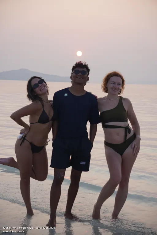 Tiga tamu trip Dahayu berfoto di tepi pantai saat matahari terbenam