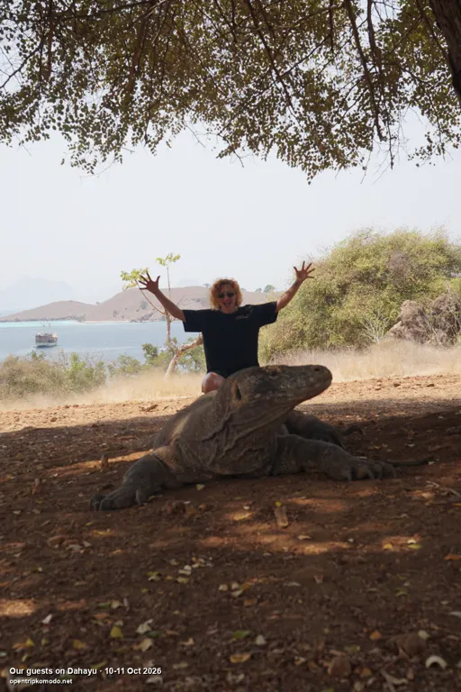 Tamu trip Dahayu melambai di belakang seekor komodo di Pulau Komodo