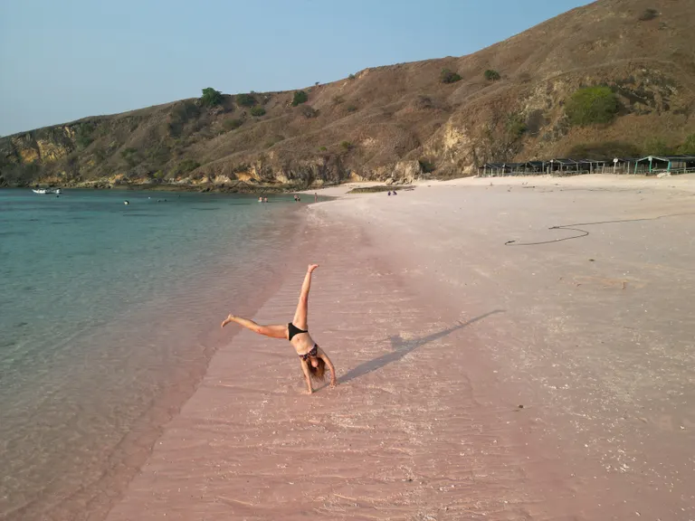 Tamu trip Deden Putra berpose di tepi air Pink Beach