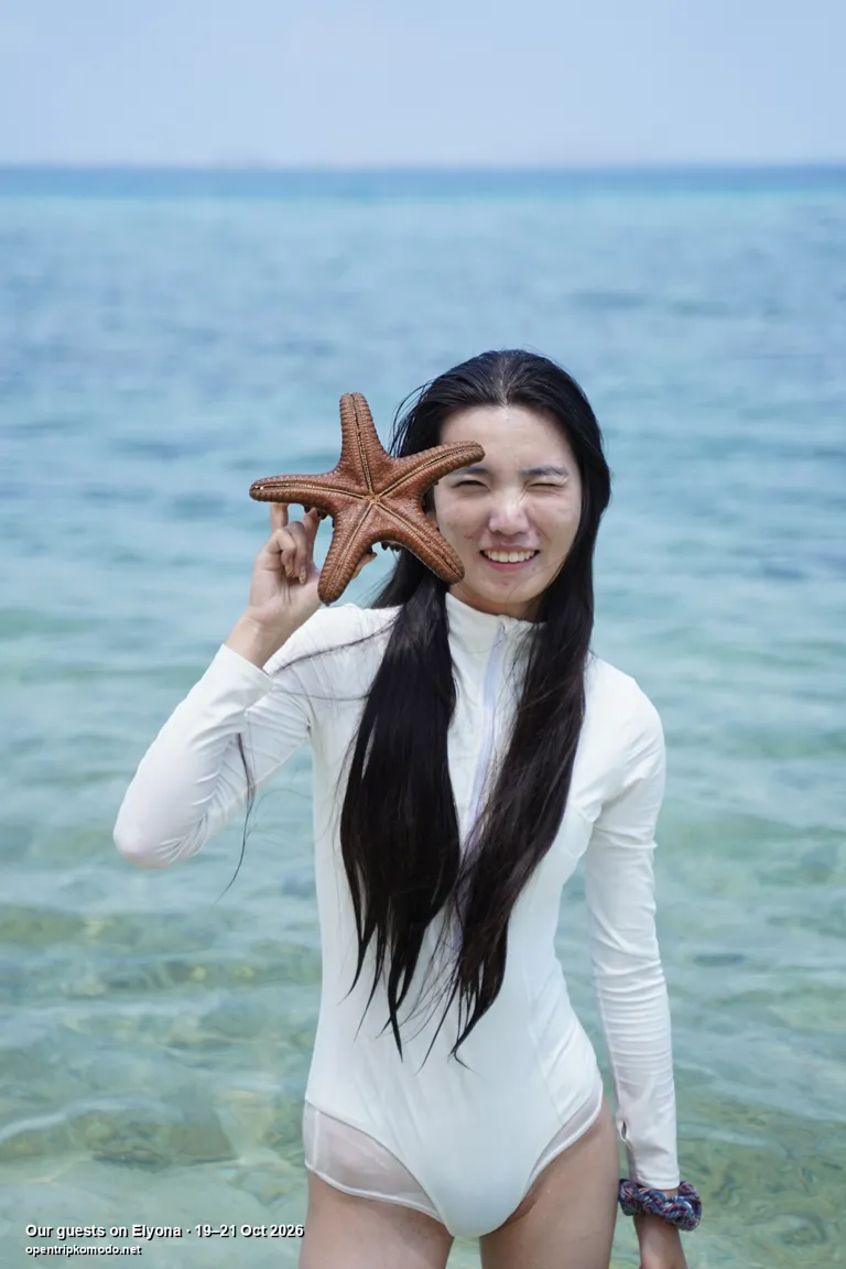 Tamu Elyona bermain air di laut jernih