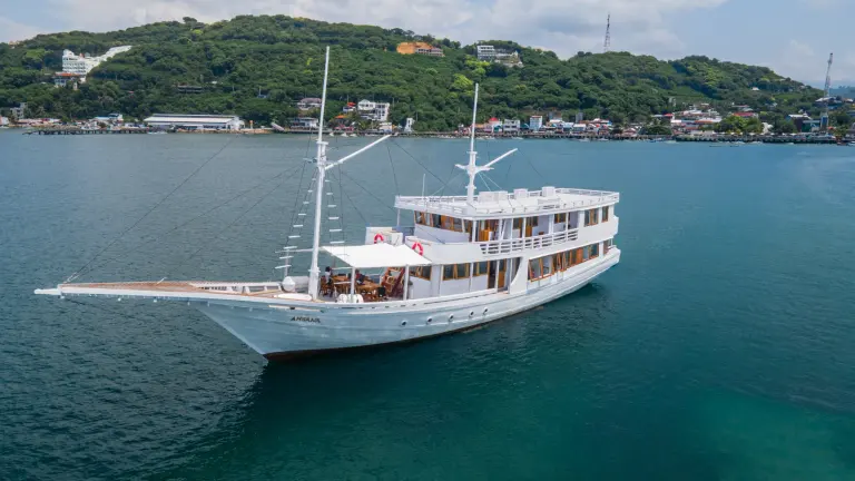 The white-hulled Ahsana phinisi at anchor off Labuan Bajo