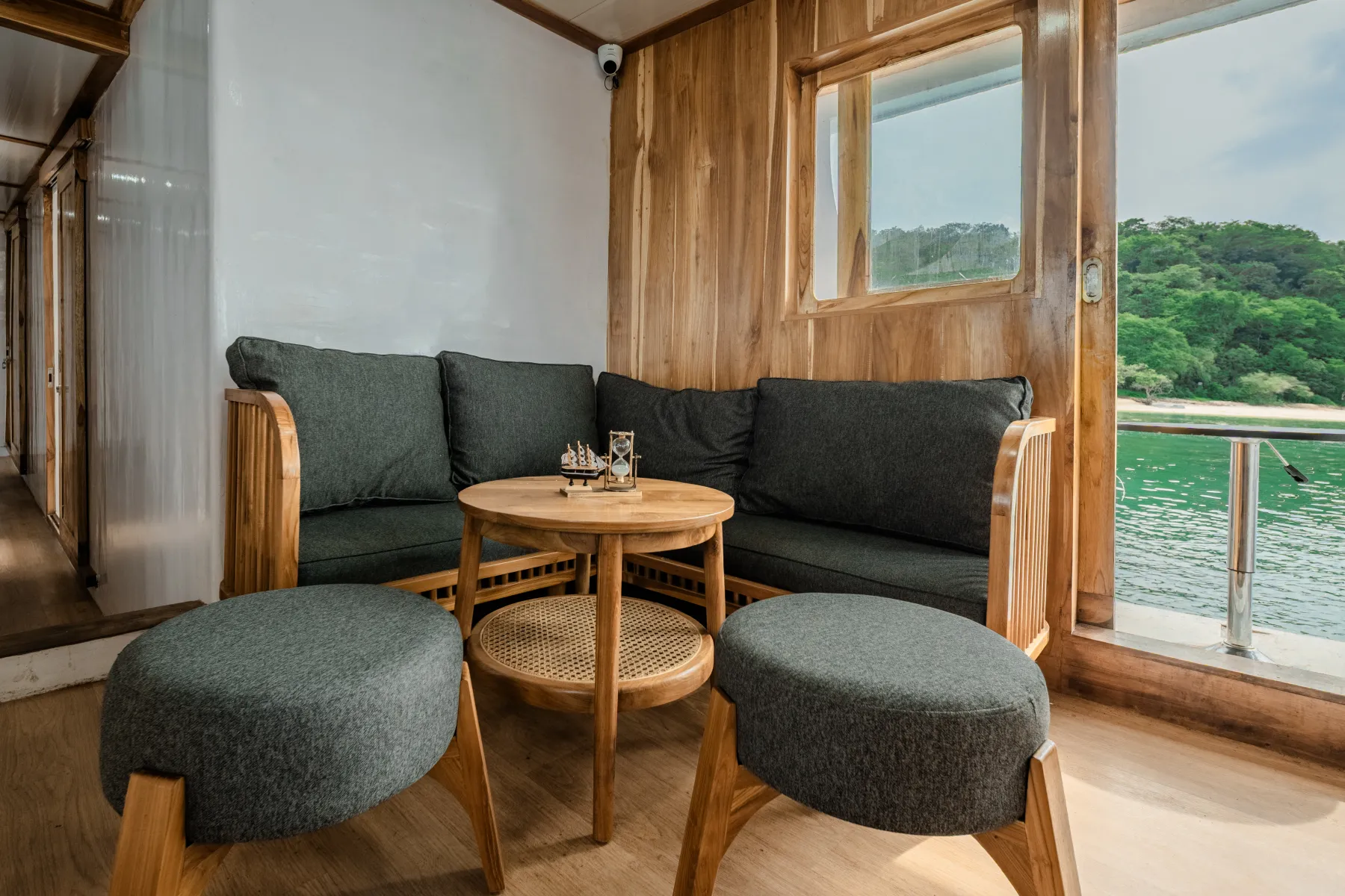 Sudut lounge Ahsana dengan sofa hijau dan meja kayu bundar