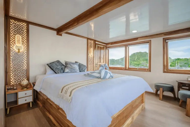Master Cabin Ahsana dengan queen bed dan jendela lebar ke laut