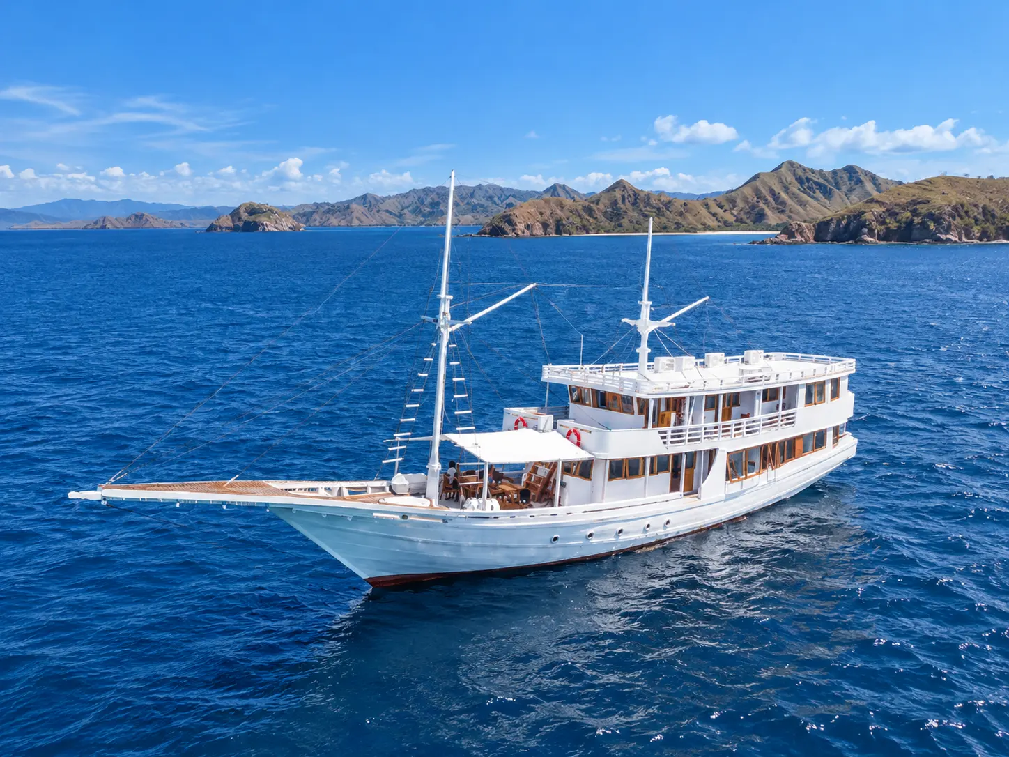 Ahsana, a two-deck white phinisi with two masts in Komodo National Park waters