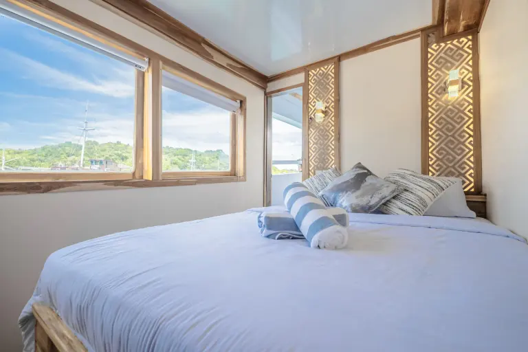 Signature Cabin Ahsana dengan queen bed dan jendela ke laut