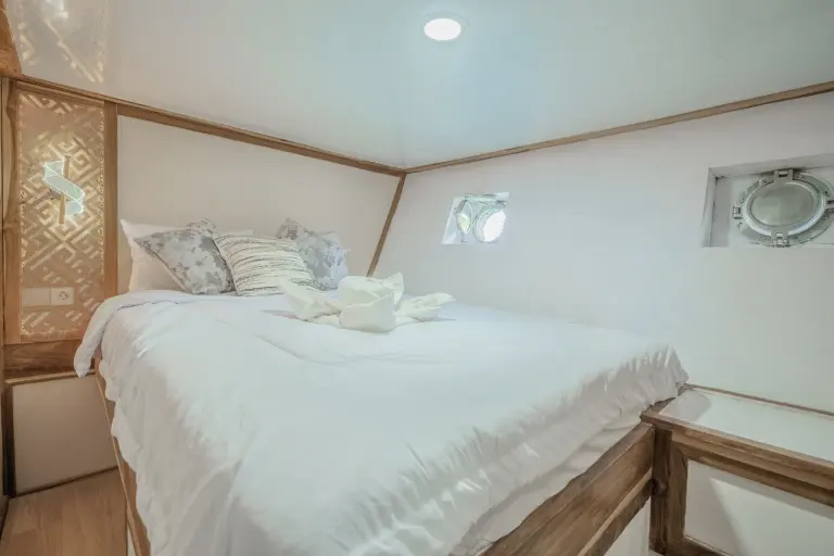 Superior Cabin Ahsana dengan queen bed dan jendela bulat