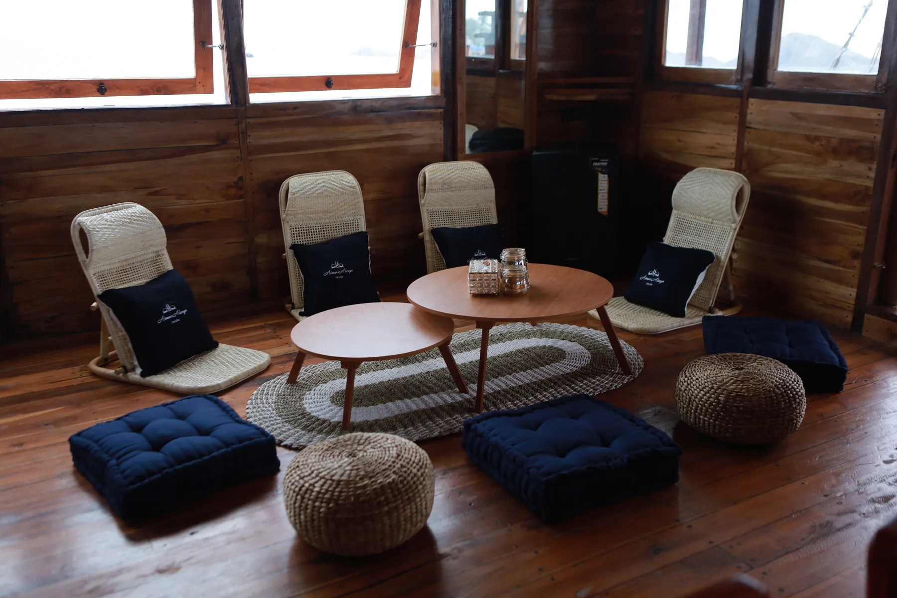 The Aimar indoor lounge with rattan chairs, round tables and floor cushions