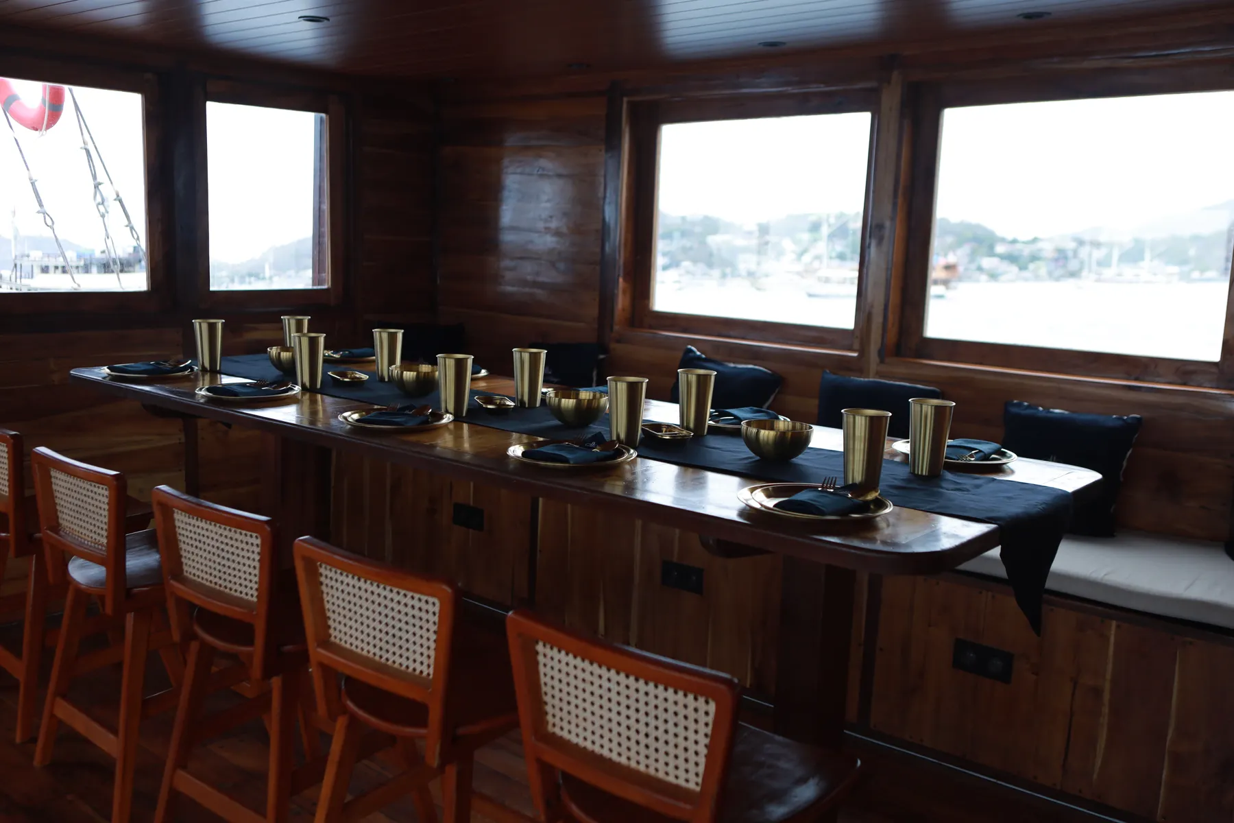 The Aimar dining room with a long table set with gold cups and rattan chairs