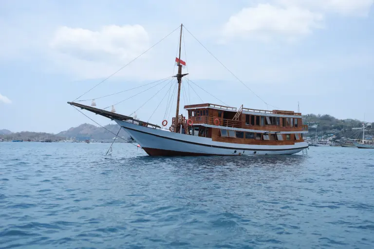Phinisi Aimar berlambung putih dengan bangunan kayu berlabuh di perairan Labuan Bajo