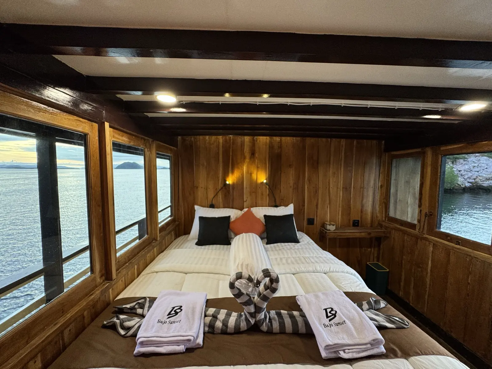 Kabin Deluxe Balcony Bajo Sunset Voyages di dek utama, katil dikelilingi tingkap ke laut