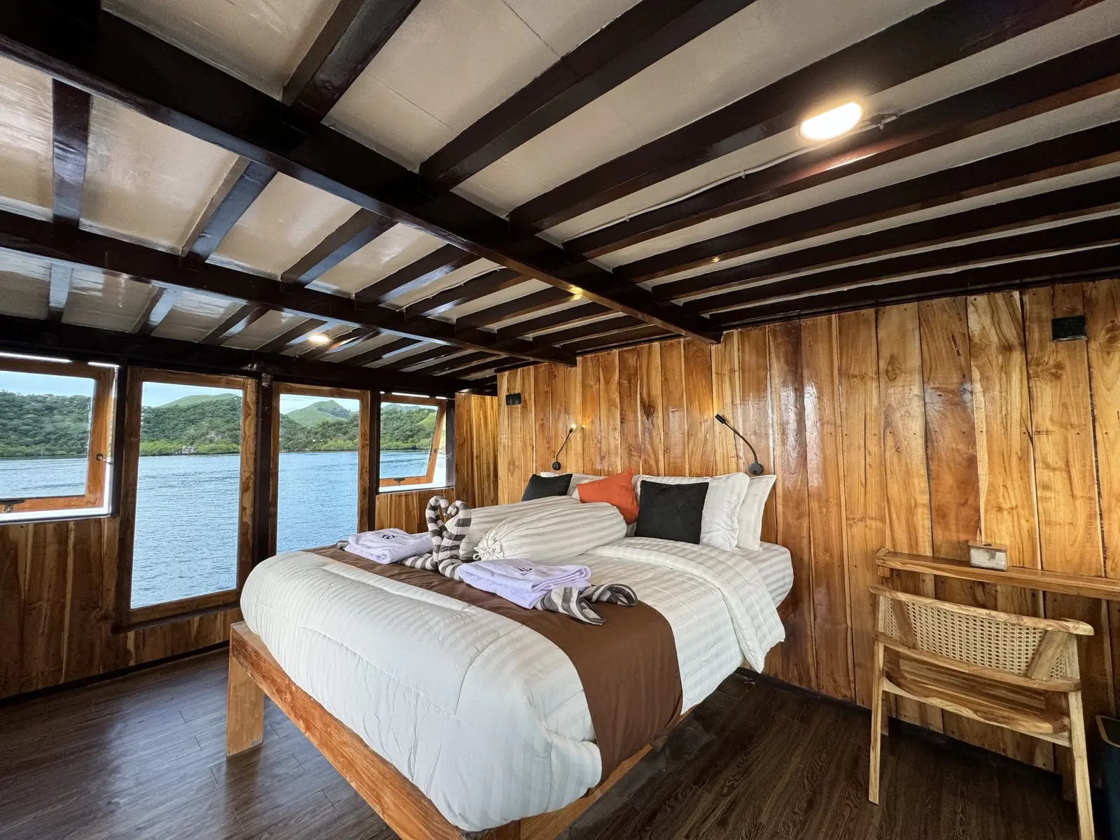 Kabin Master Balcony Bajo Sunset Voyages di dek atas dengan katil queen dan deretan tingkap laut