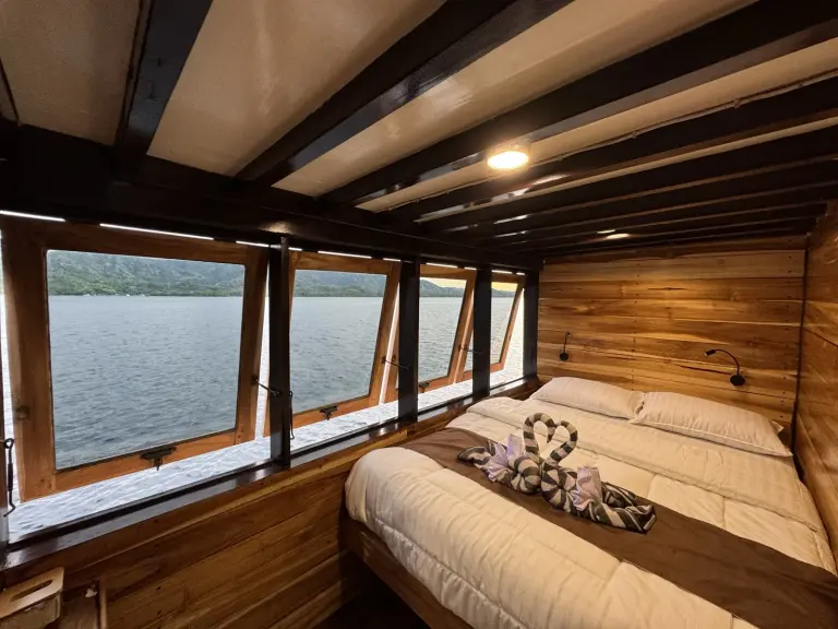 Kabin Signature Ocean Bajo Sunset Voyages dengan deretan jendela di sisi ranjang