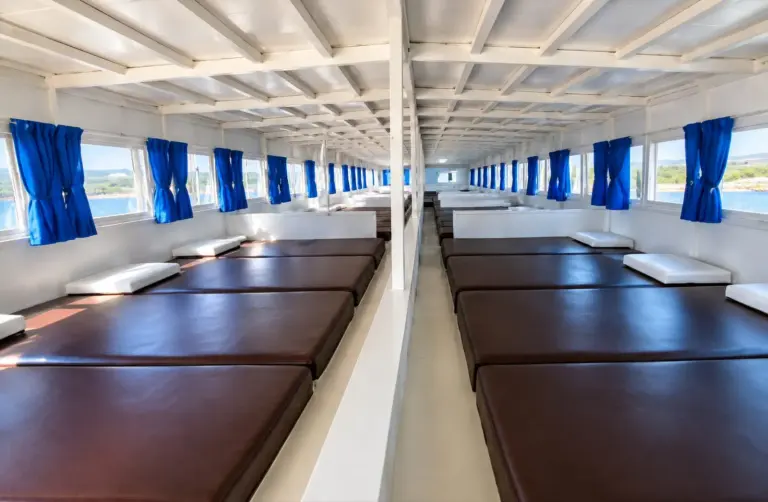 Sharing Deck Bintang Laut, kasur berjajar di dek tertutup berjendela
