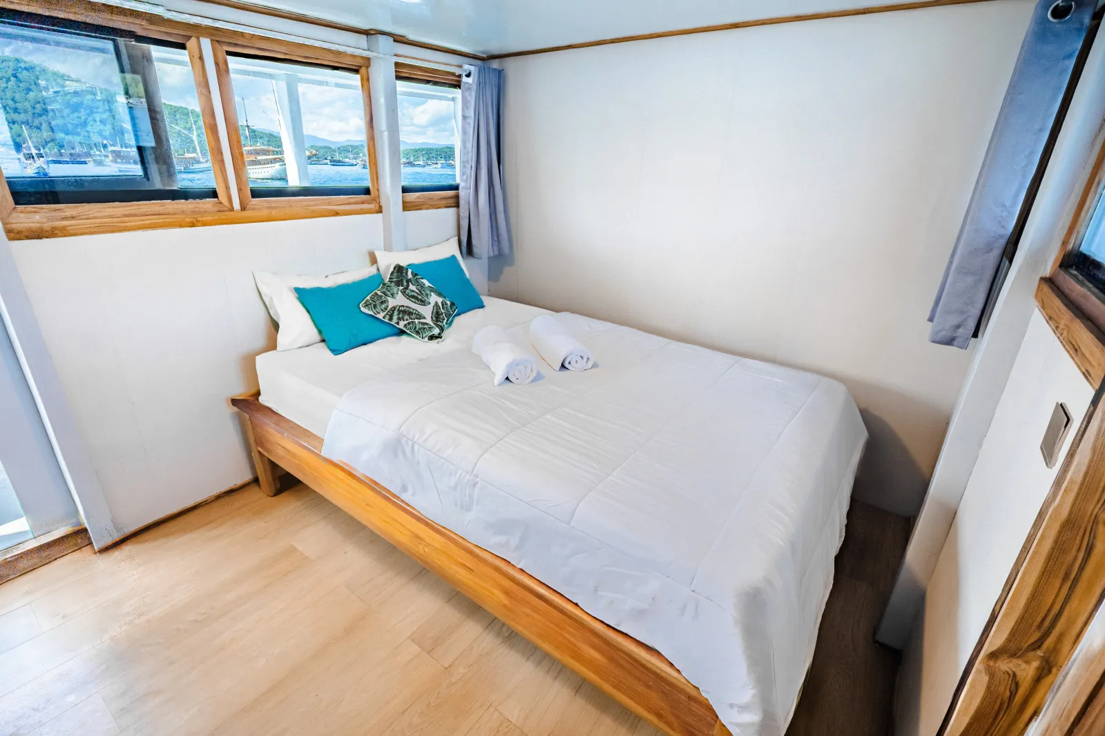 Private Cabin With Balcony Bombana 01, ranjang double dan pintu kayu ke balkon