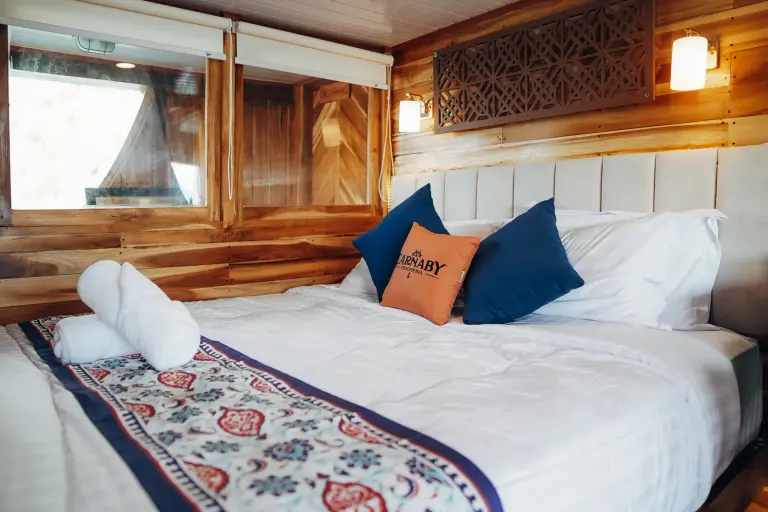 Deluxe Cabin Bulukumba dek atas Carnaby II, ranjang double dengan jendela laut di sampingnya
