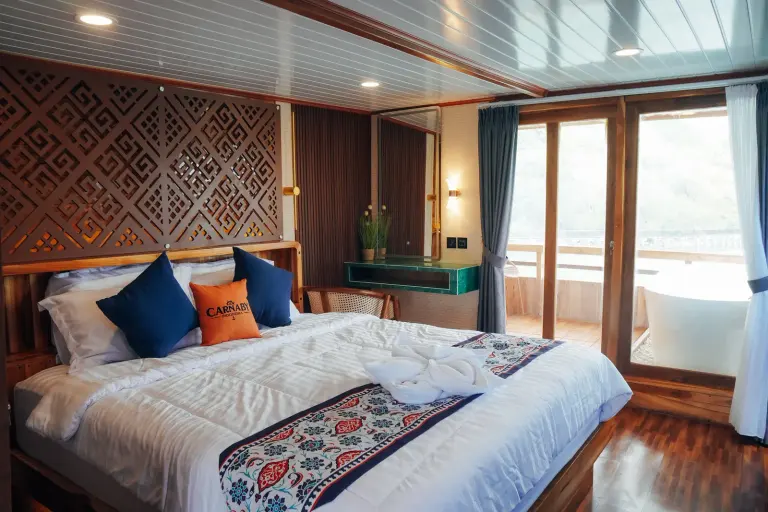 Master Cabin dek atas Carnaby II, ranjang double berkepala ukiran dan pintu kaca ke balkon