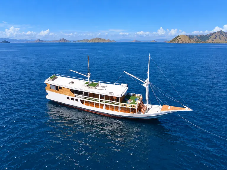 Dinara, a white-hulled wooden phinisi in Komodo National Park waters