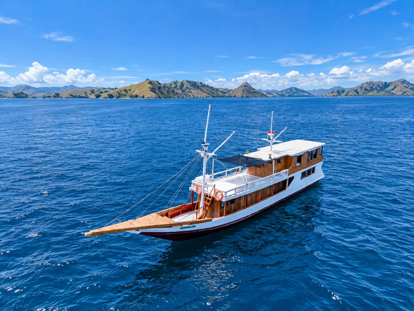 Dunia Baru Bajo, a wooden boat with a white hull in Komodo National Park waters
