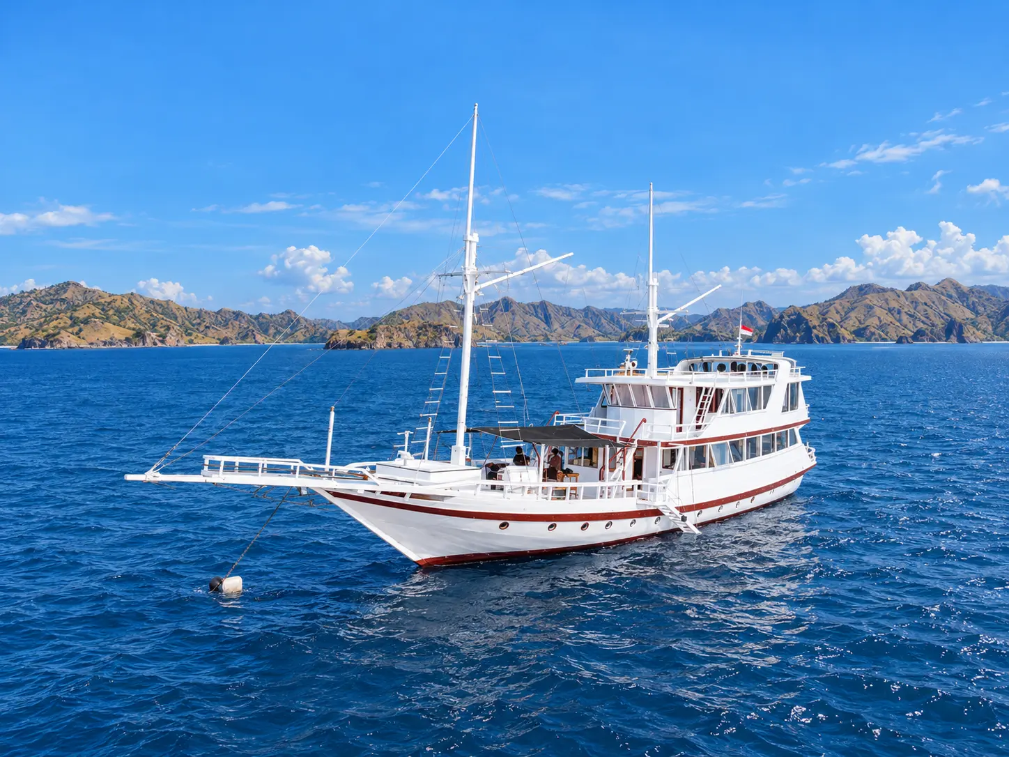 Gaisan, a two-deck white phinisi with two masts in Komodo National Park waters