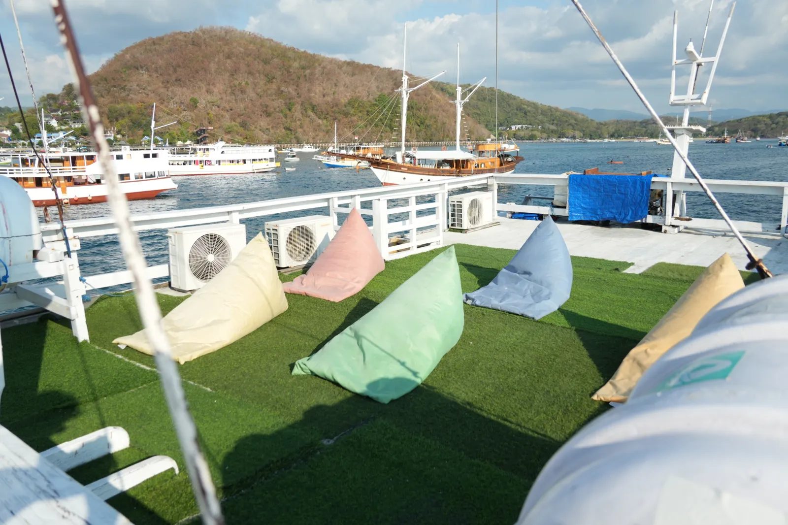Dek santai Hatira Hela dengan beanbag menghadap pelabuhan