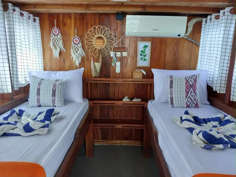 Kabin Deluxe Twin Ayla dengan dua ranjang single dan rak kayu di tengah