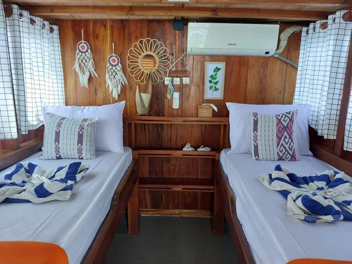 Kabin Deluxe Twin Ayla dengan dua ranjang single dan rak kayu di tengah