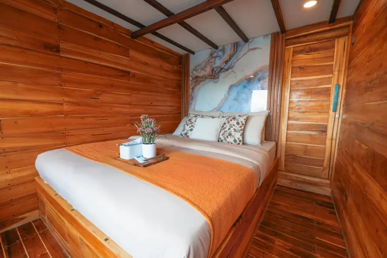 Bumi Deluxe Suite Akassa dengan ranjang double dan dinding kayu penuh