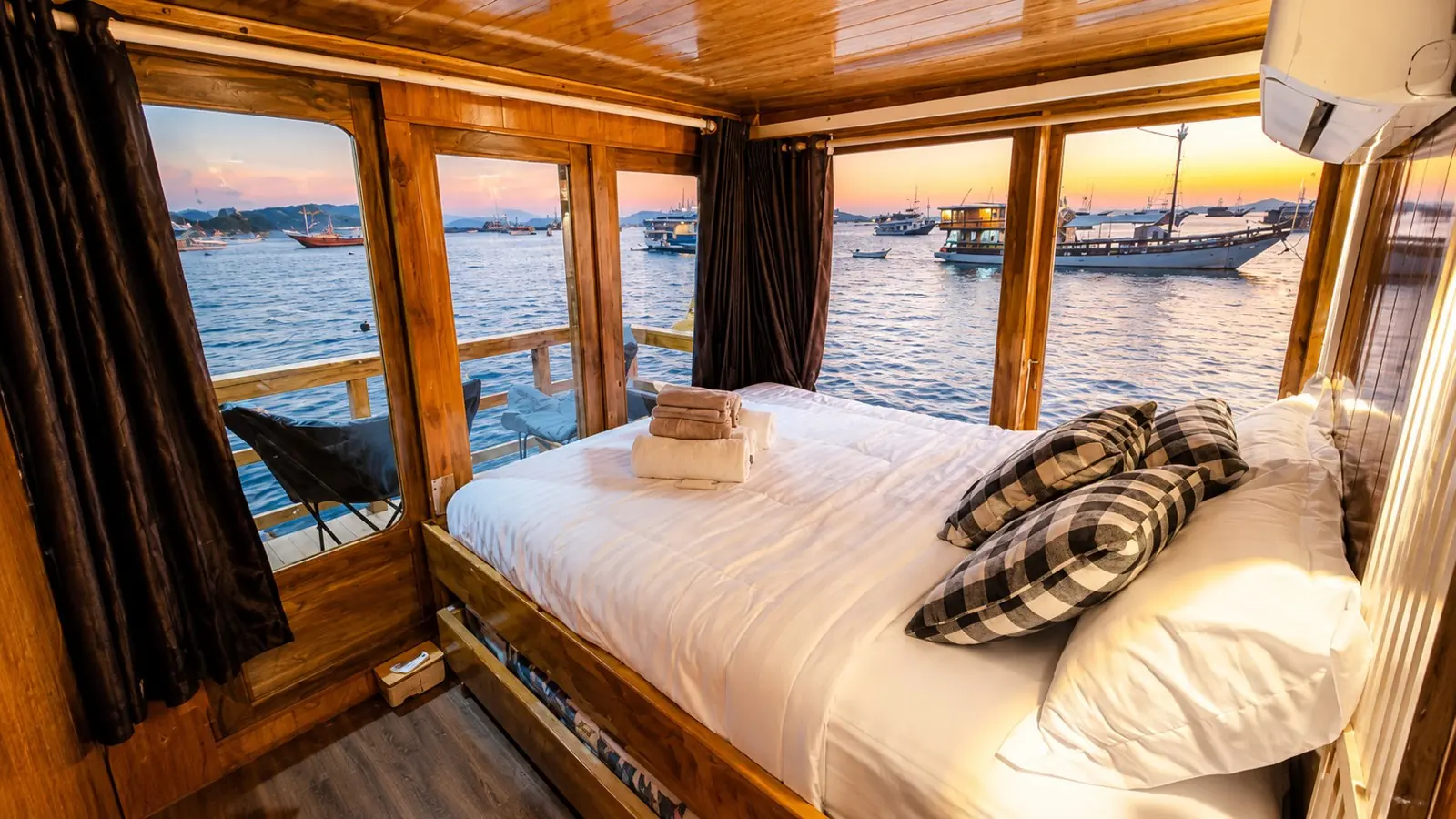 Deluxe Cabin Blessing dengan ranjang double menghadap jendela lebar ke teluk