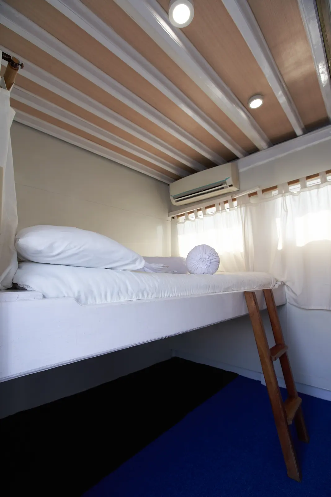 Deluxe Cabin Ladyana, ranjang besar ditinggikan, AC di atas jendela bertirai putih