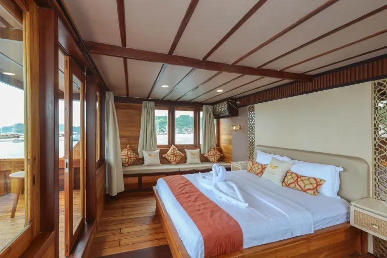 Master Cabin Elrora dengan ranjang besar dan jendela kaca ke laut