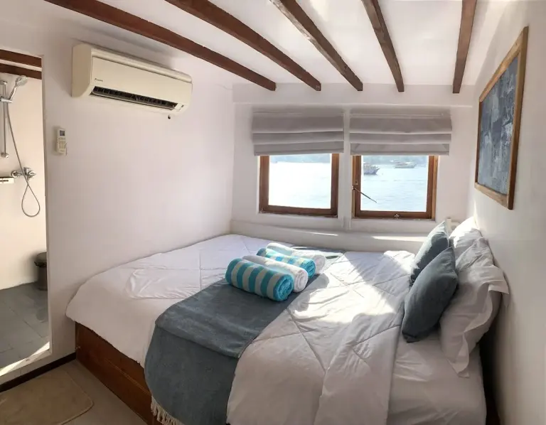 Kabin Pangrango dengan kasur queen, AC, dan jendela ke laut