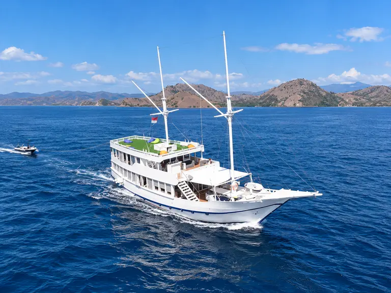 Mosalaki, kapal putih bertingkat melaju di laut biru di perairan Taman Nasional Komodo
