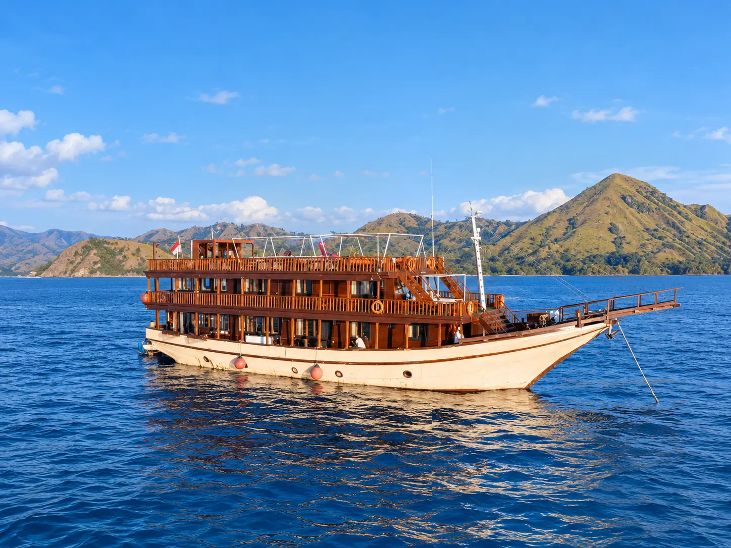 Ocean Pro 2, a multi-deck wooden boat with a cream hull in Komodo National Park waters