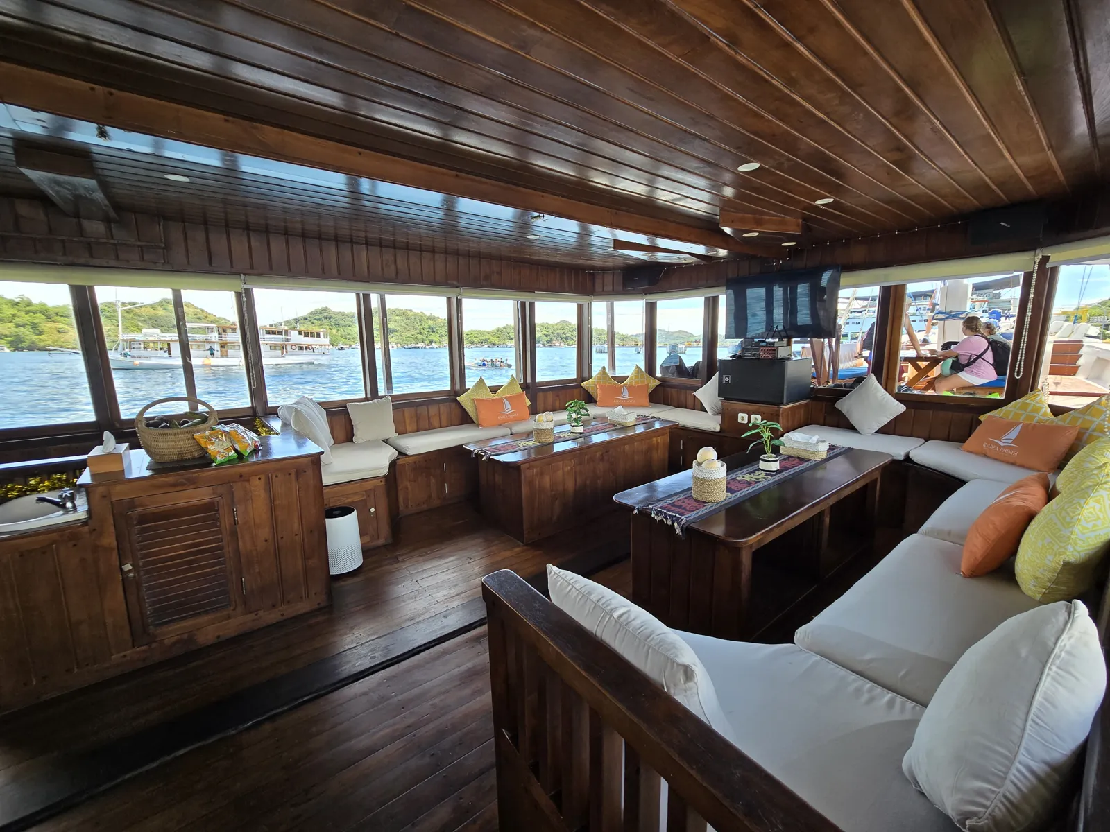 Lounge kapal Pelita Arunika dengan sofa dan jendela lebar