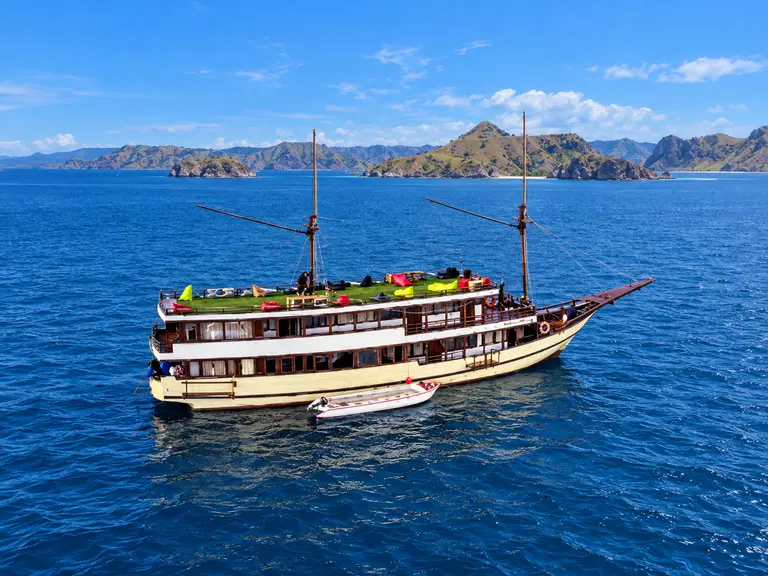 Princess Nabila, a cream-hulled wooden phinisi with two masts in Komodo National Park waters