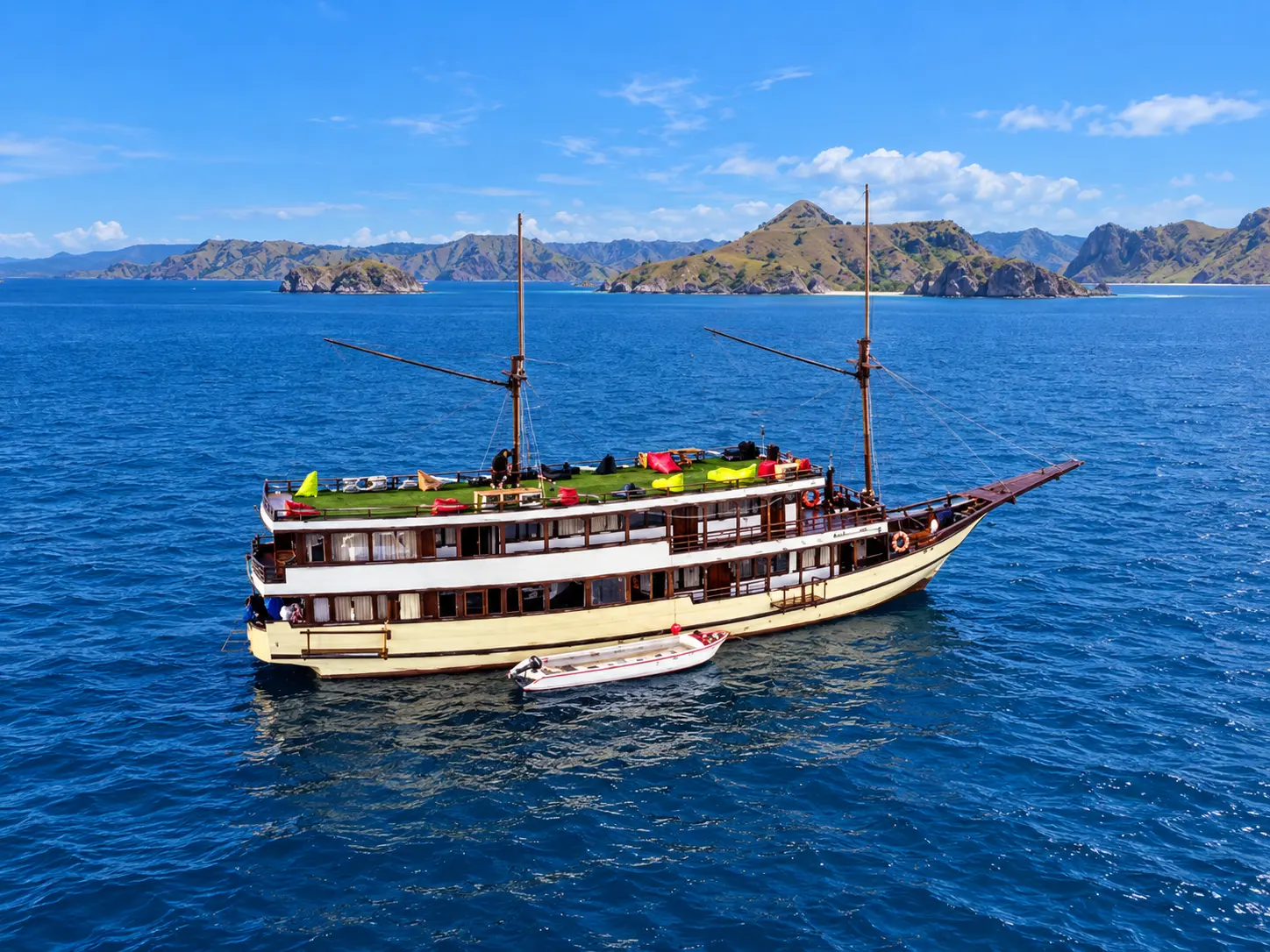 Princess Nabila, a cream-hulled wooden phinisi with two masts in Komodo National Park waters