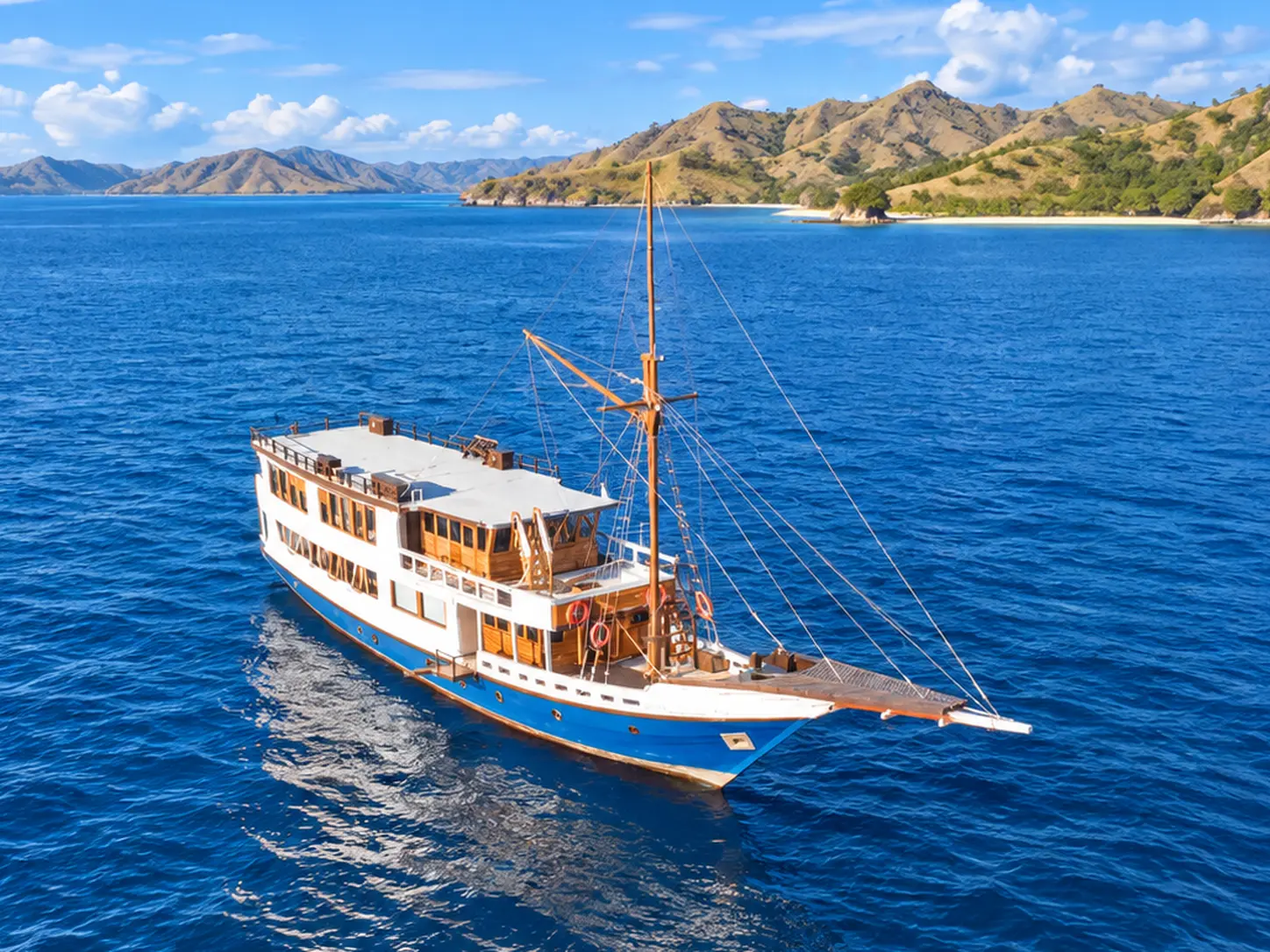 Raja Bintang 03, a wooden boat with a blue and white hull in Komodo National Park waters