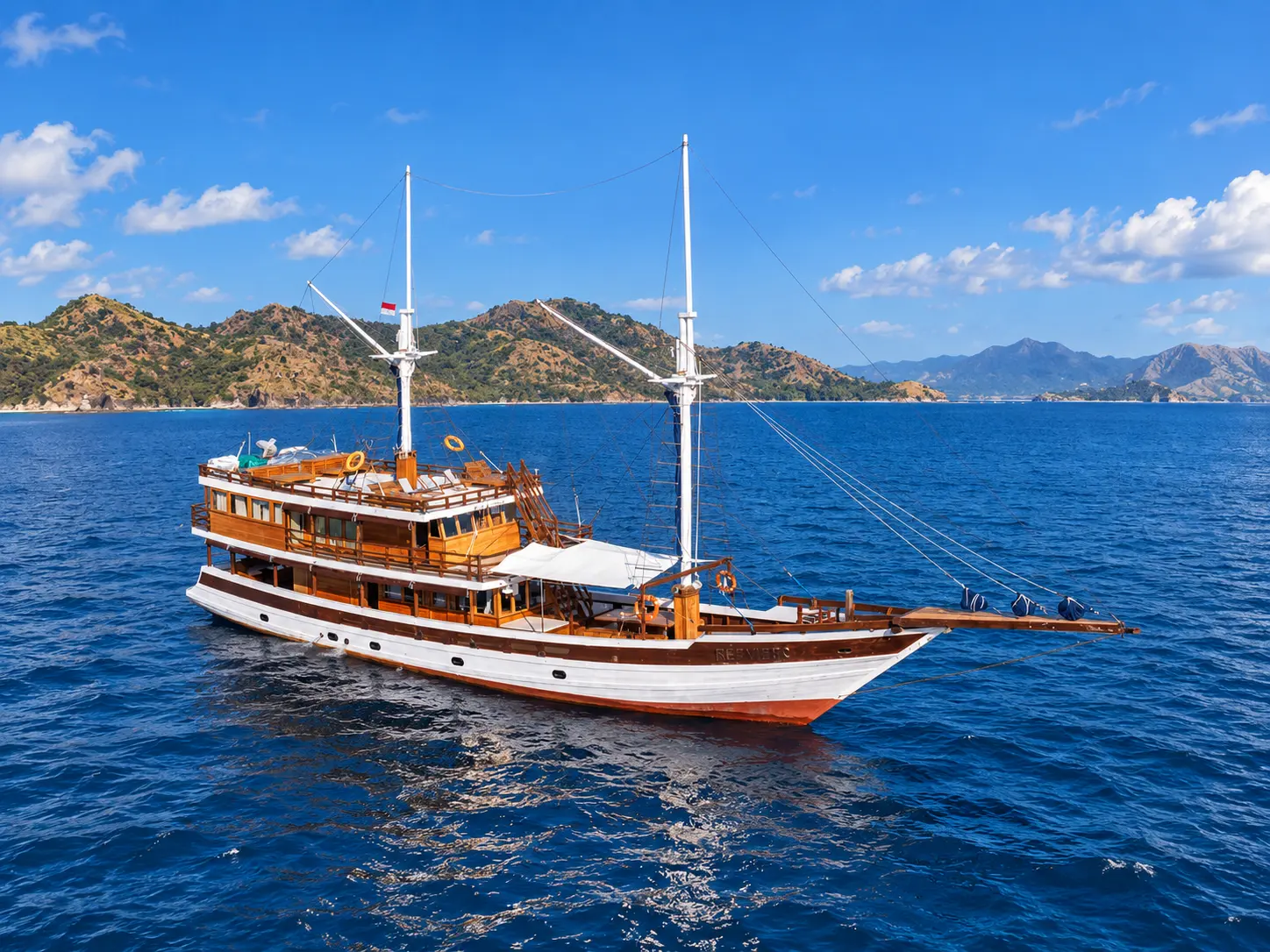 Refviero, a white-hulled two-masted wooden phinisi in Komodo National Park waters
