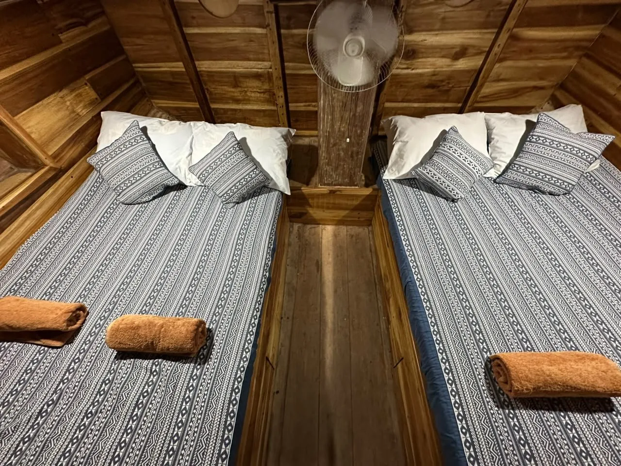Kabin 3 Sabbar Cruise, dua kasur double bersprei motif berdampingan di kabin kayu