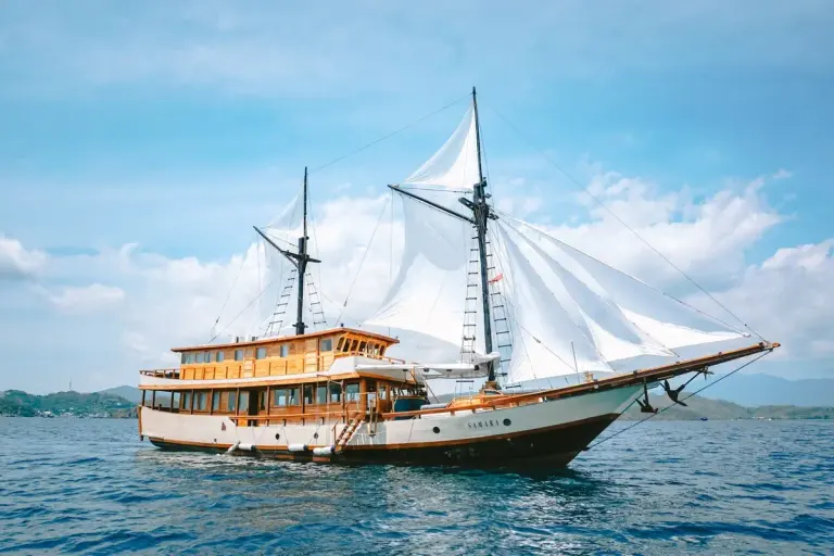 Phinisi Samara I berlayar dengan layar putih terkembang di perairan Komodo