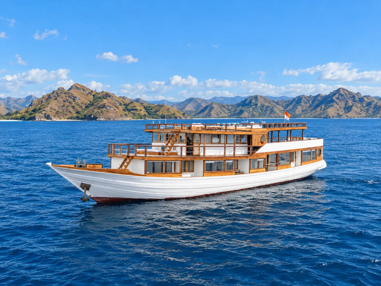 Sora, a two-deck wooden boat with a white hull in Komodo National Park waters