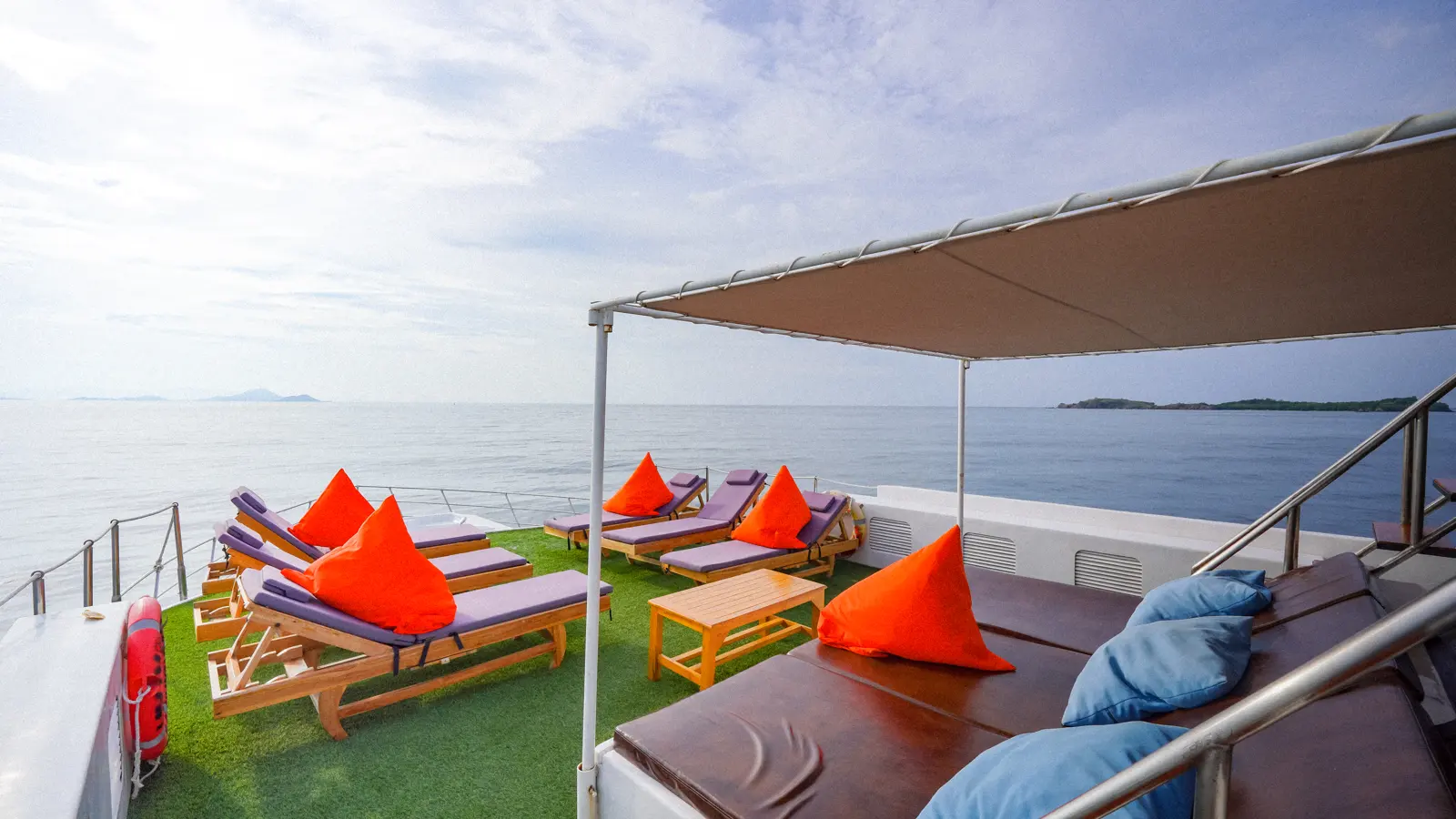 Sundeck Ocean Angel di bawah kanopi, deretan kursi berjemur dan kasur santai berbantal biru