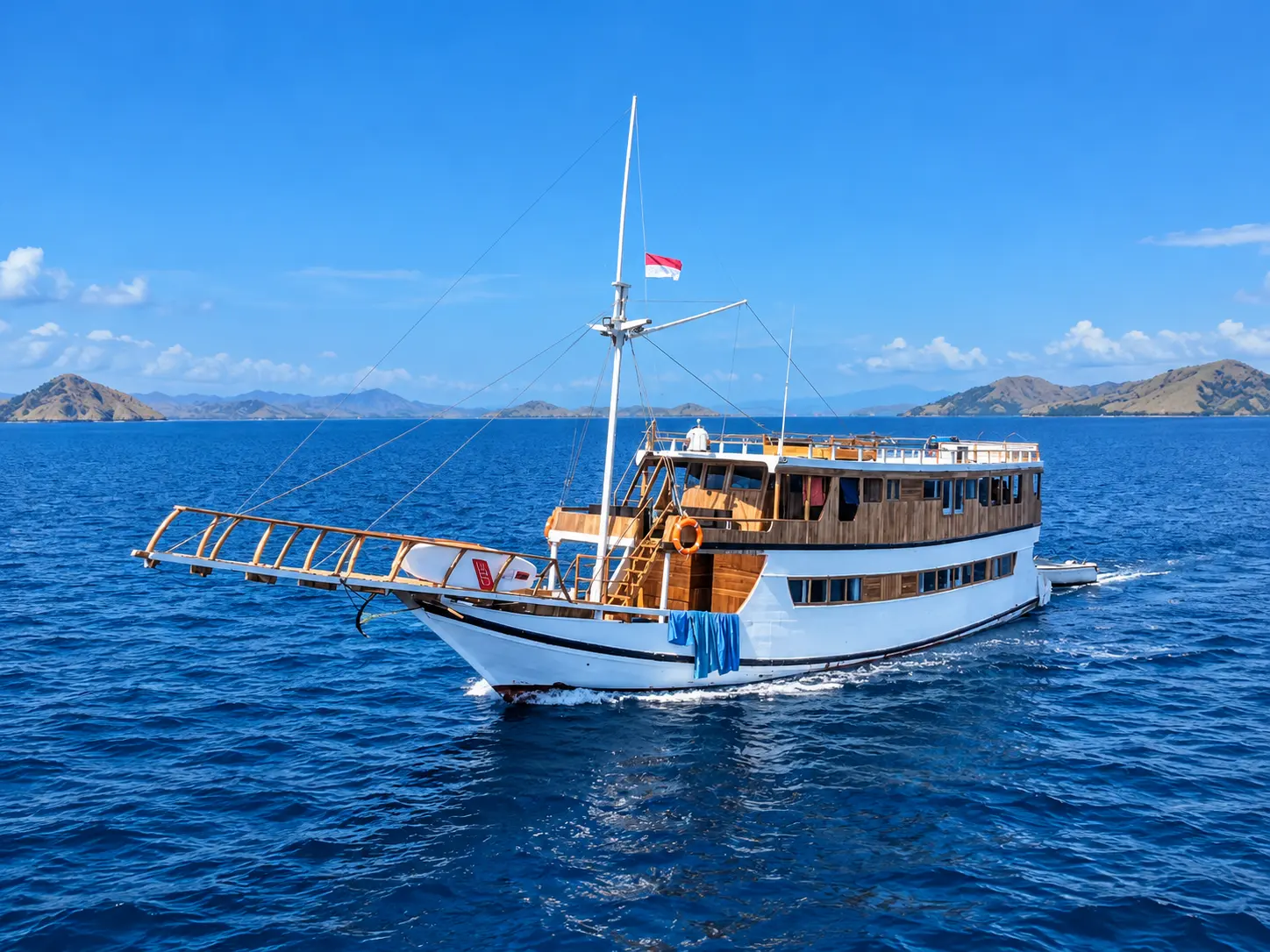 Yukai, a white-hulled wooden phinisi in Komodo National Park waters